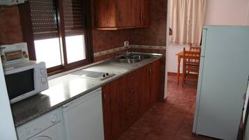 Frigorífico grande, microondas y utensilios de cocina