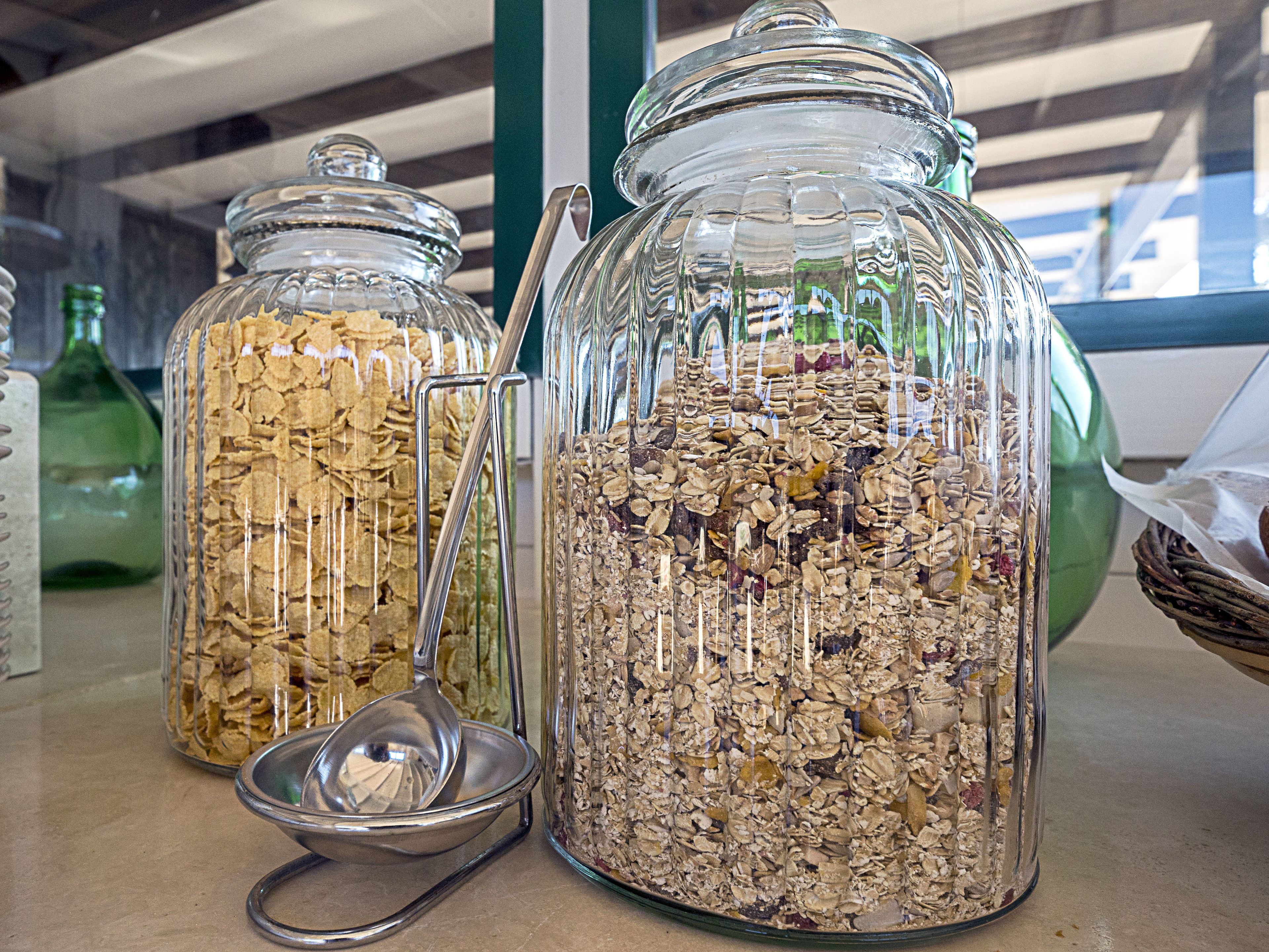 Tres frascos de vidrio llenos de cereal sobre una mesa.