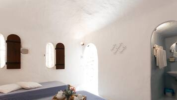 Una habitación con cama, ventana, espejo y lavamanos.