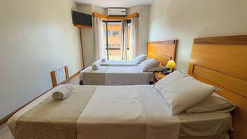 Camera d'albergo con due letti, una televisione a parete, un condizionatore d'aria e vista esterna.