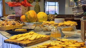 Un bufé con diversos alimentos, incluyendo queso, pan y frutas.