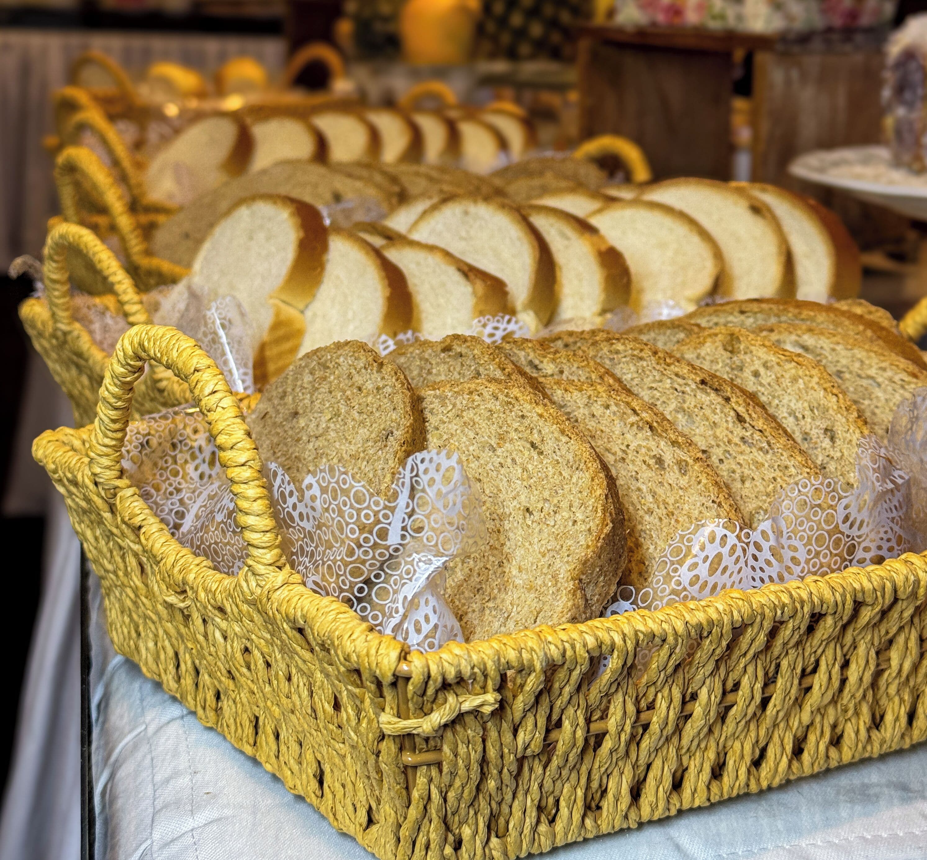 Ein Korb aus Weidengeflecht mit Brotscheiben auf einem Tisch.