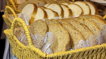 Ein Korb aus Weidengeflecht mit Brotscheiben auf einem Tisch.