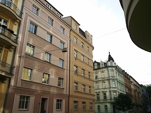 Um edifício de vários andares com estilo arquitetônico clássico, com varandas e grandes janelas.