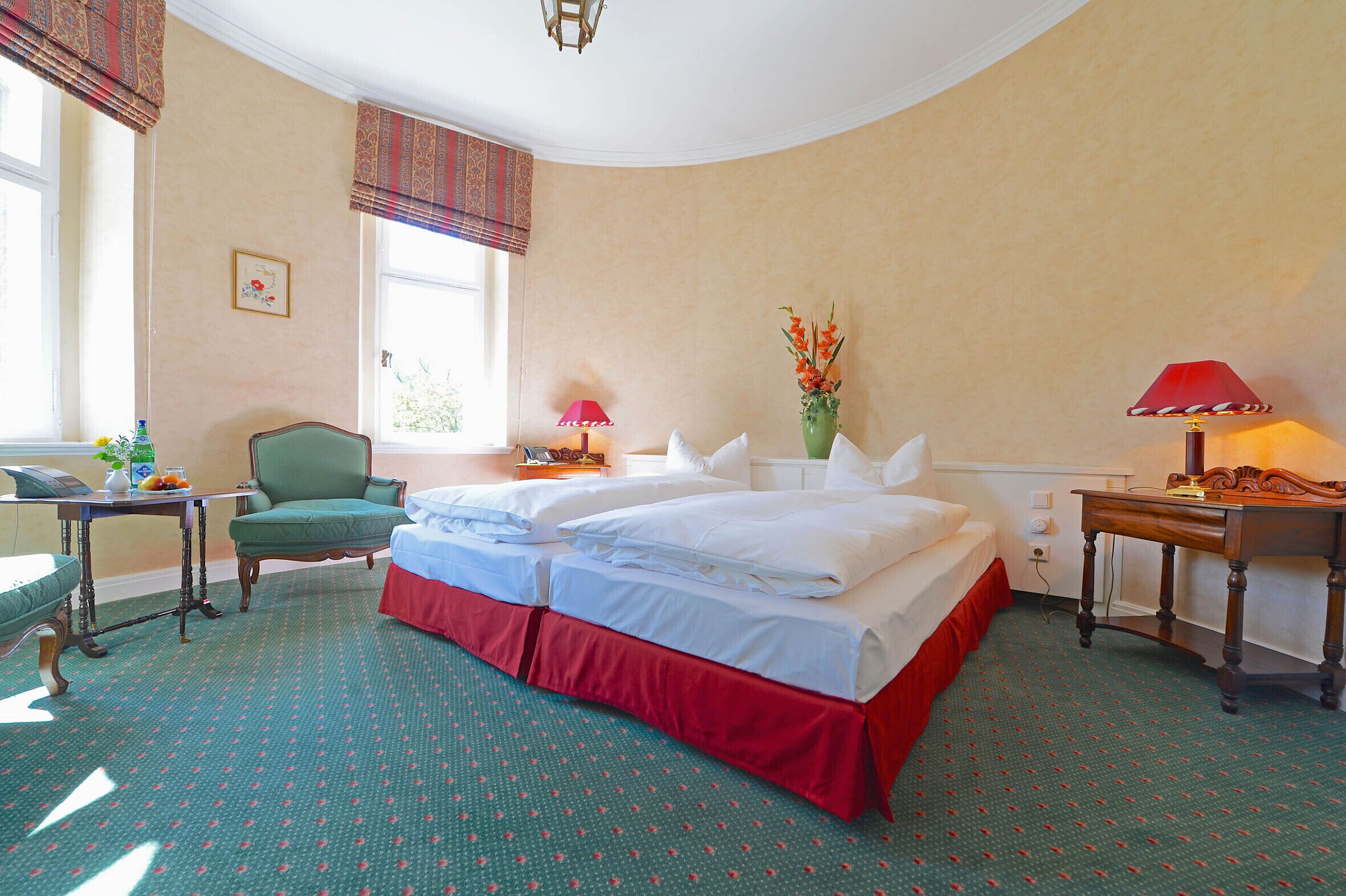 Una habitación de hotel con cama, una silla, una mesa y una ventana.