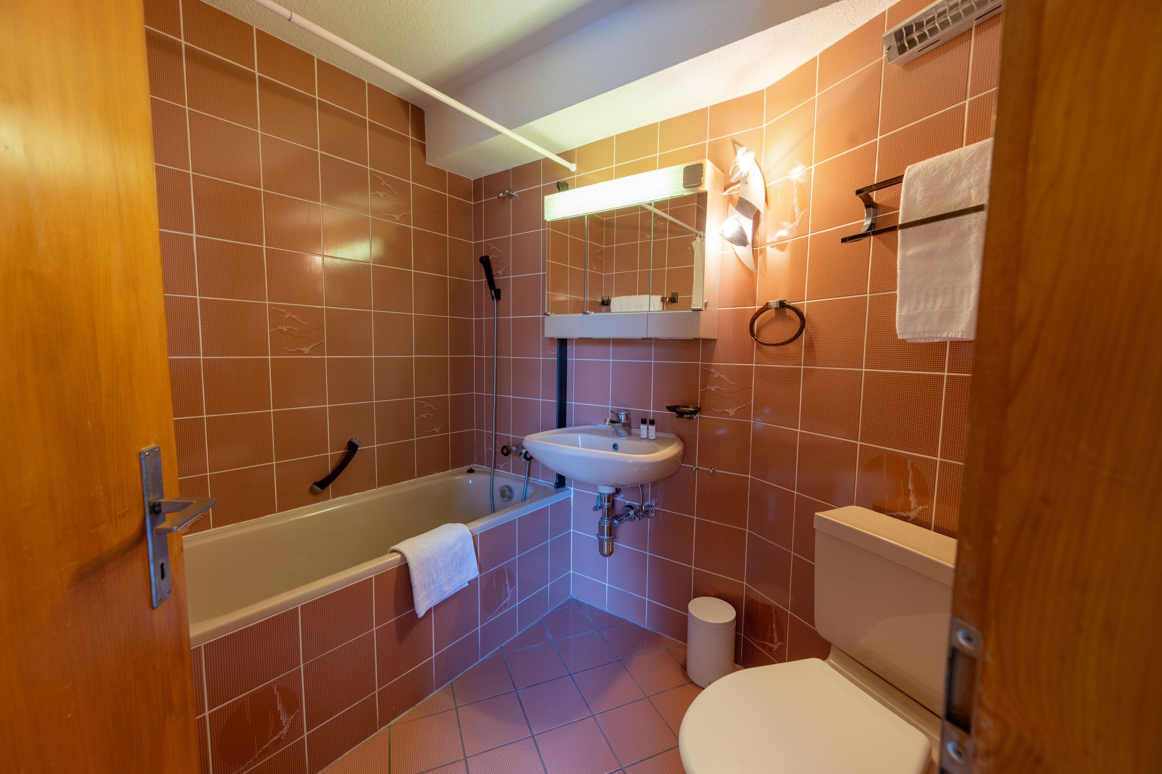 Une salle de bain avec une baignoire, un lavabo, des toilettes et un miroir.