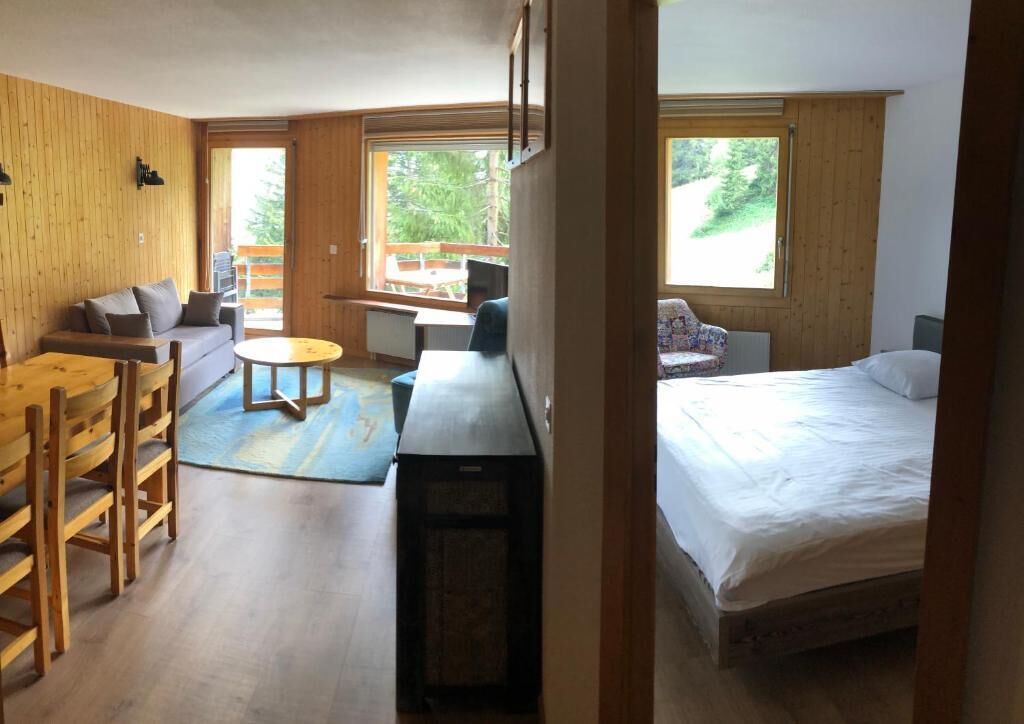 Una habitación acogedora con cama, escritorio, silla y sofá.