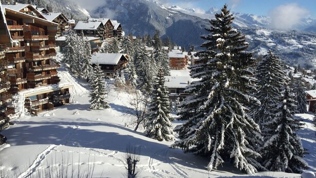 A snow-covered mountain village with wooden buildings and snow-covered trees. - Eden Resort Anzère (Ayent)