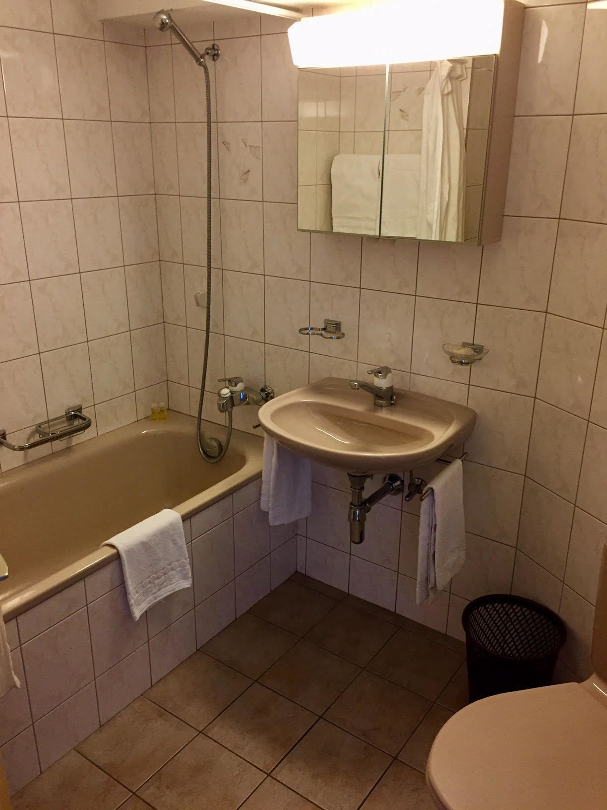 Une salle de bain avec une baignoire, un lavabo, un miroir et des toilettes.