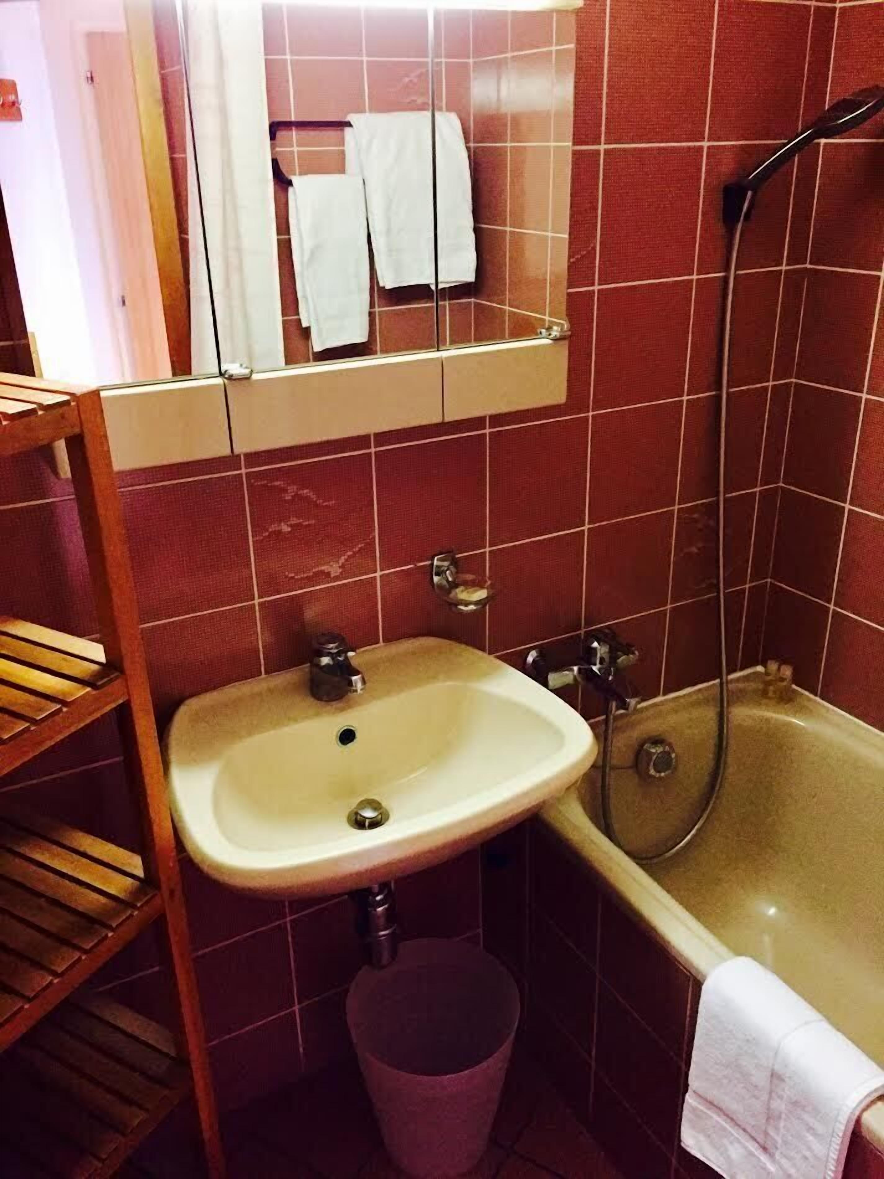 Un baño con lavamanos, espejo y bañera.
