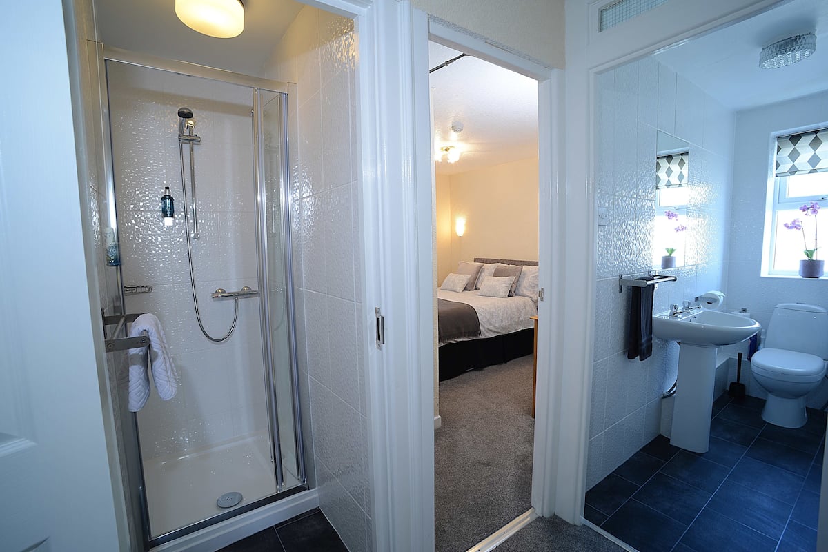 A bathroom with a shower, sink, and toilet.