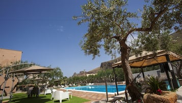 Una piscina al aire libre de temporada, sombrillas