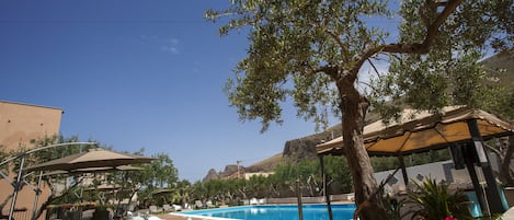 Una piscina al aire libre de temporada, sombrillas