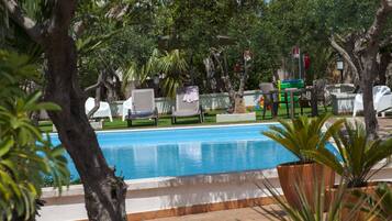 Una piscina al aire libre de temporada, sombrillas