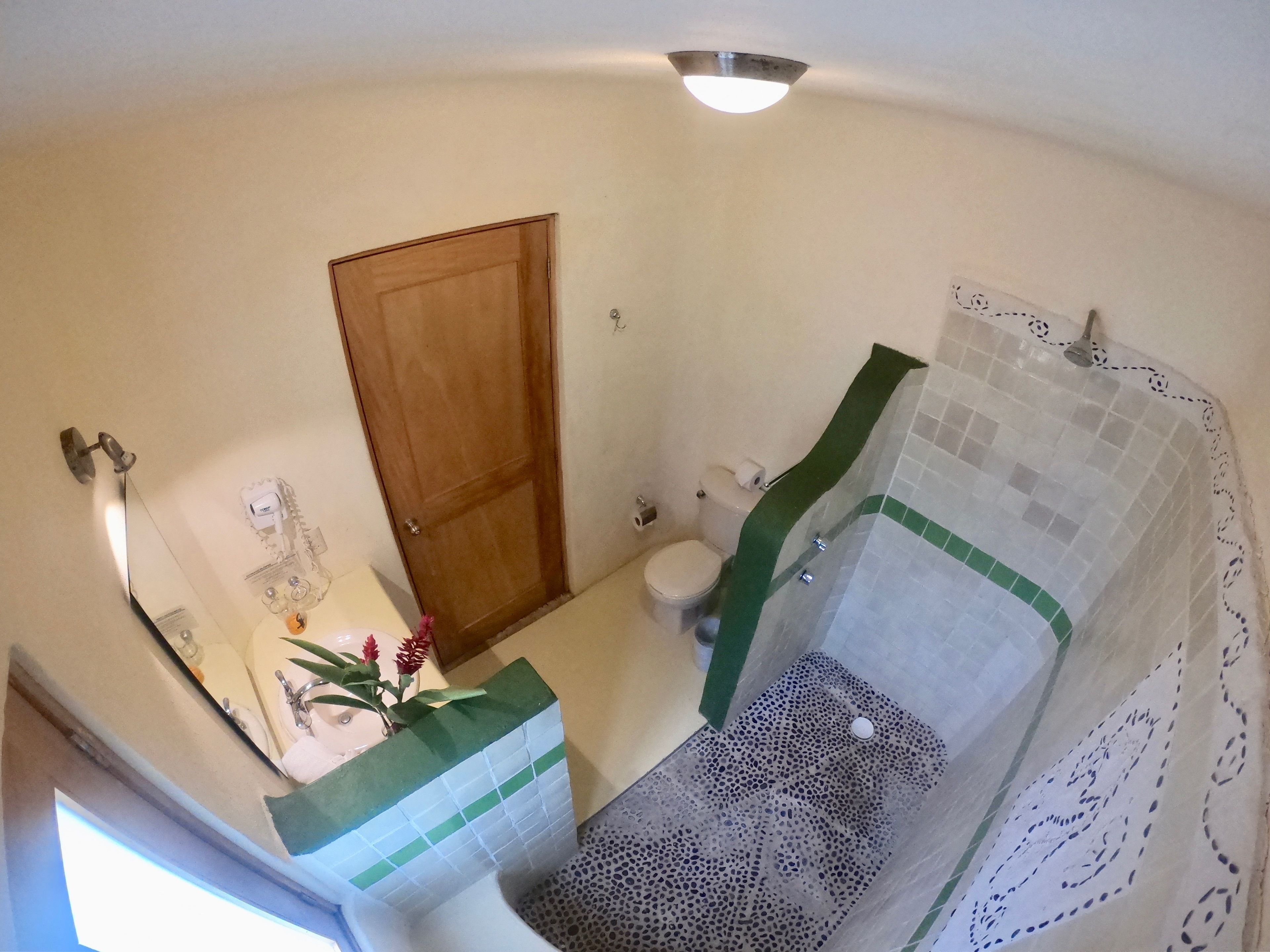 Une salle de bain comprenant des toilettes, un lavabo et un espace douche.