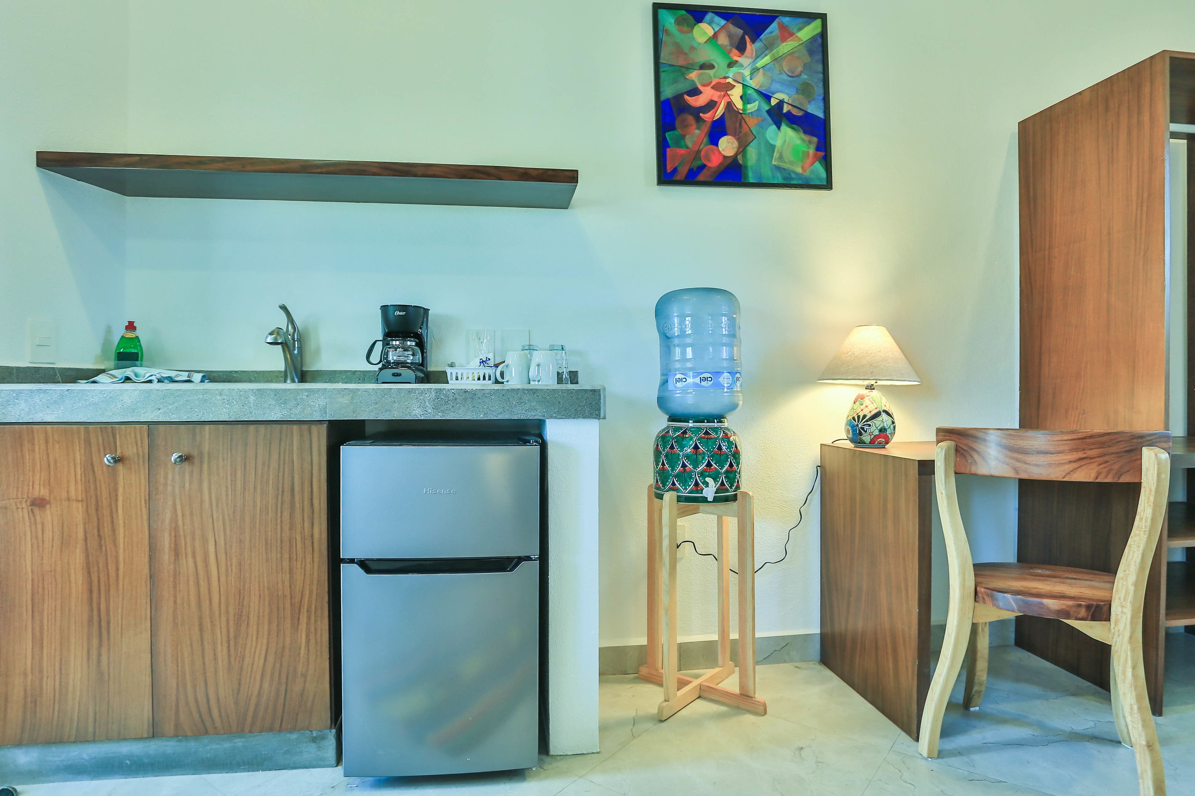 Cucina con frigorifero, macchina del caffè, dispenser d'acqua e mobili in legno.