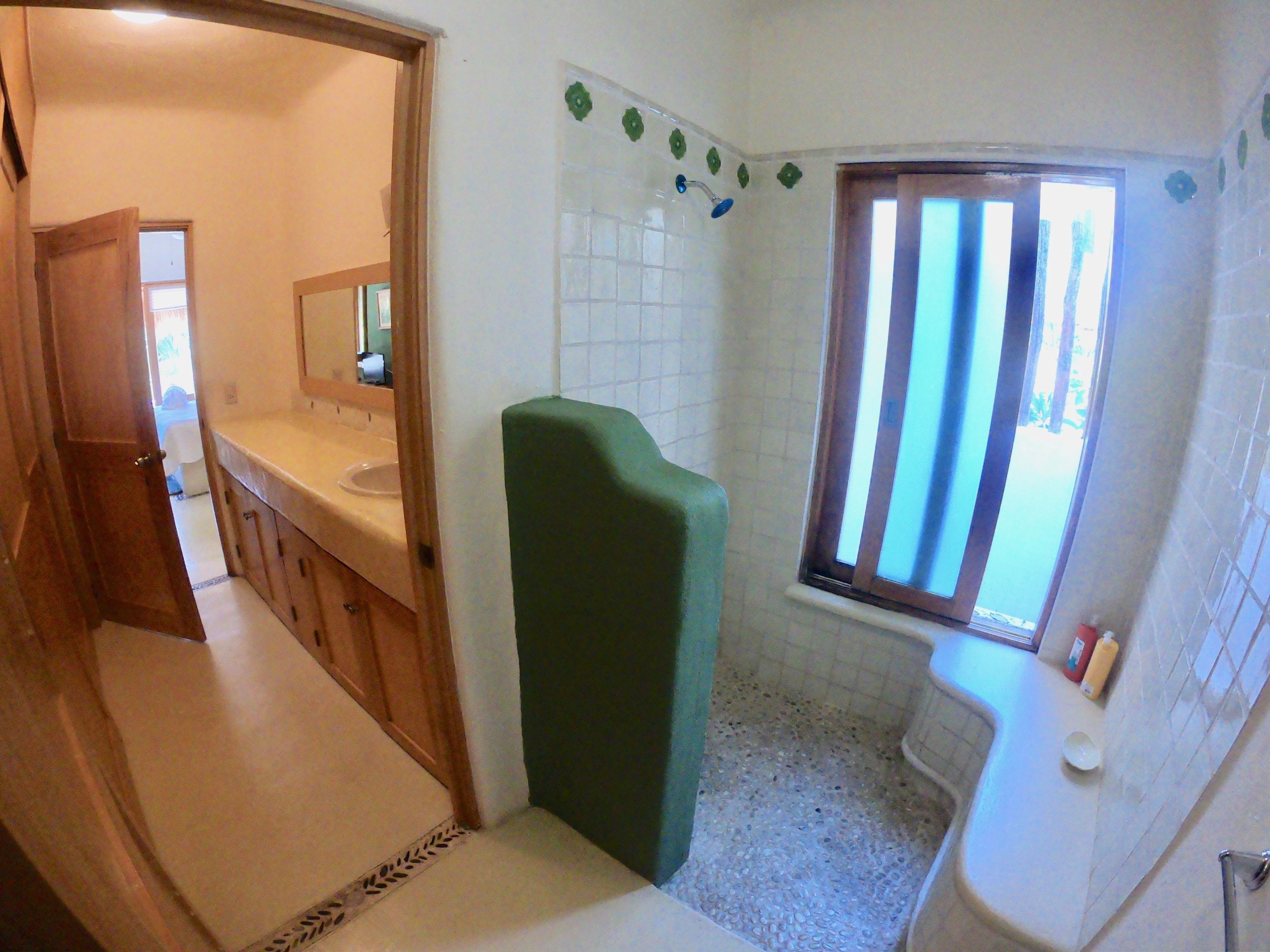 Casa de banho com sanita, lavatório e zona de duche.