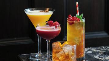 Tres bebidas sobre una mesa de mármol con fondo de madera oscura.
