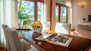 A wooden dining table with a book and a vase of flowers. - Casabella Residenza d'Epoca (Vaglia)