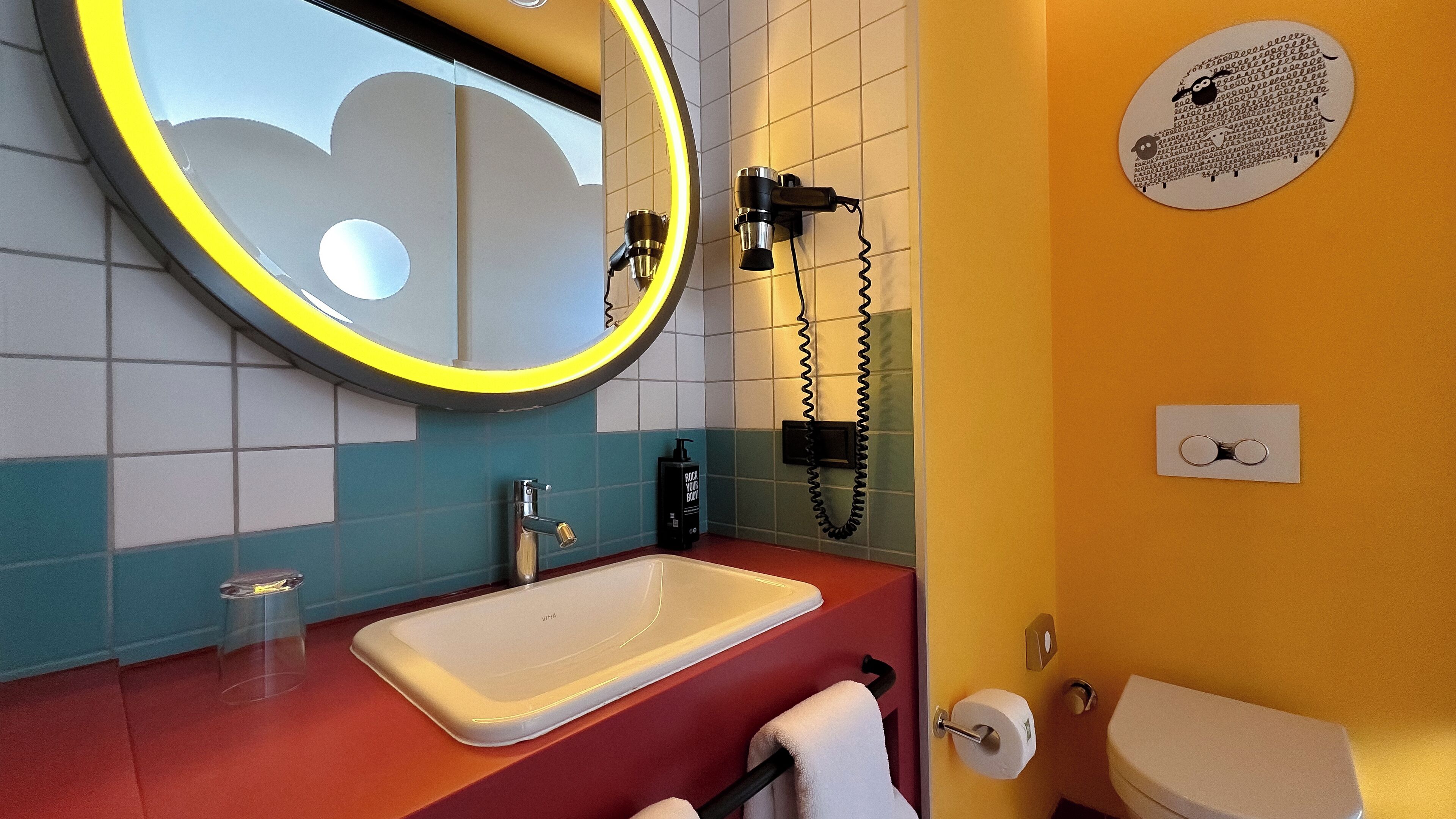 A bathroom with a sink, mirror, and toilet.