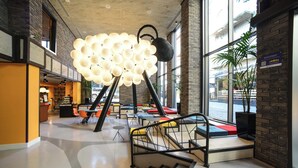A spacious lobby with a modern staircase, seating areas, and a unique spherical light fixture. - Ibis Styles Tbilisi Center (Tbilisi)