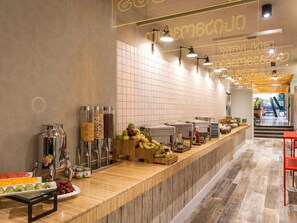 A buffet area with various food items and condiments.