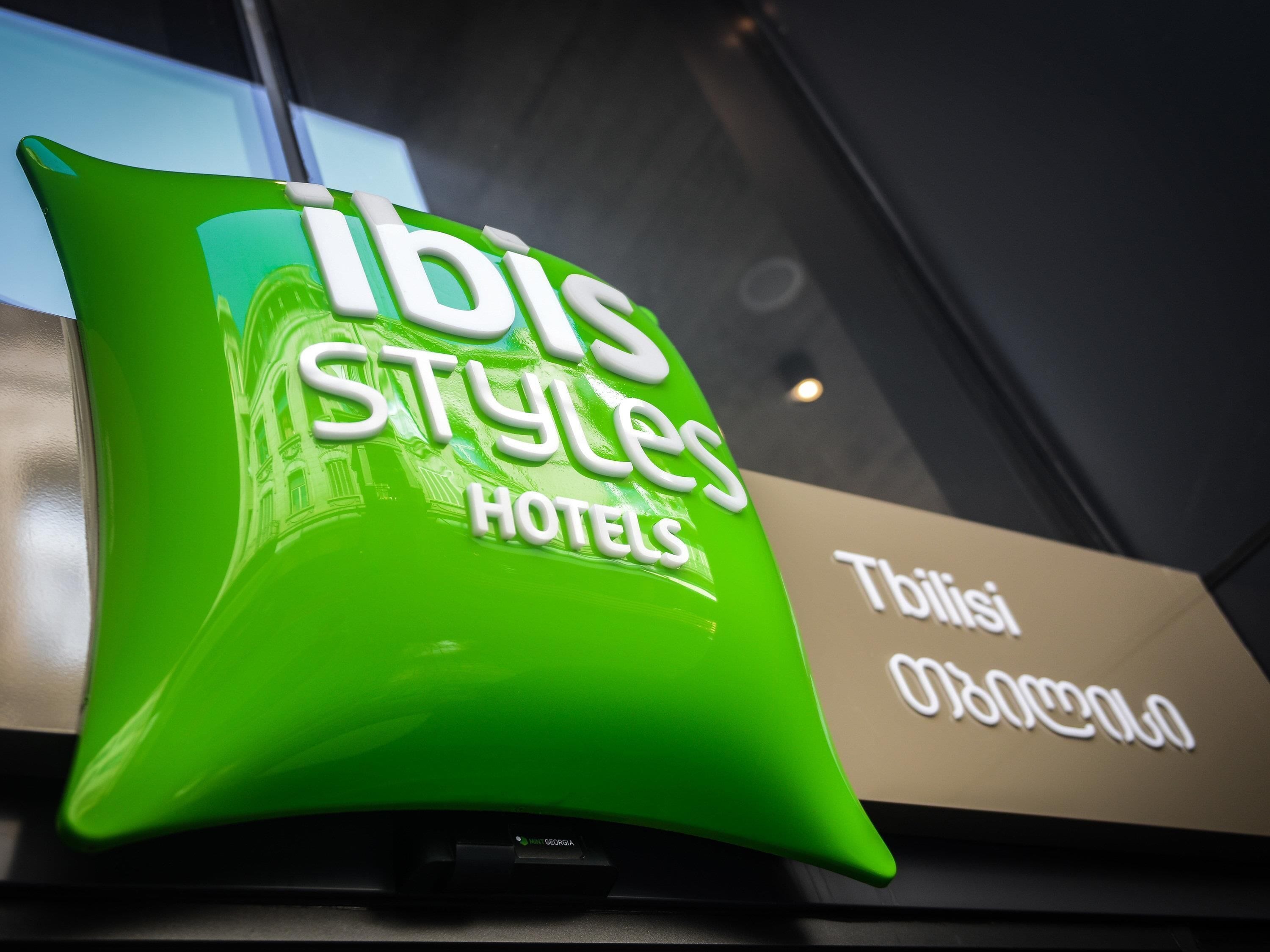Ein grünes Schild mit der Aufschrift 'IBIS Styles Hotels'.