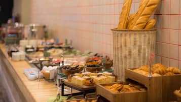 A buffet with various food items including bread, pastries, and desserts.