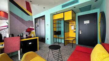 A modern room with a sofa, a small table, a TV, and a storage unit with shelves.