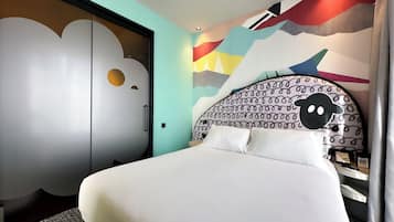A modern bedroom with a bed, a wardrobe, and a wall with abstract art.