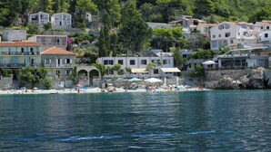 Un pueblo costero con edificios, una playa y un litoral rocoso.