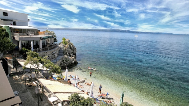 Un hotel costero con aguas cristalinas, una playa y vistas al mar.