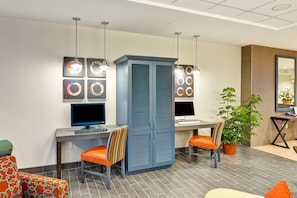 A modern office space with two desks, chairs, and a decorative wall with circular patterns.