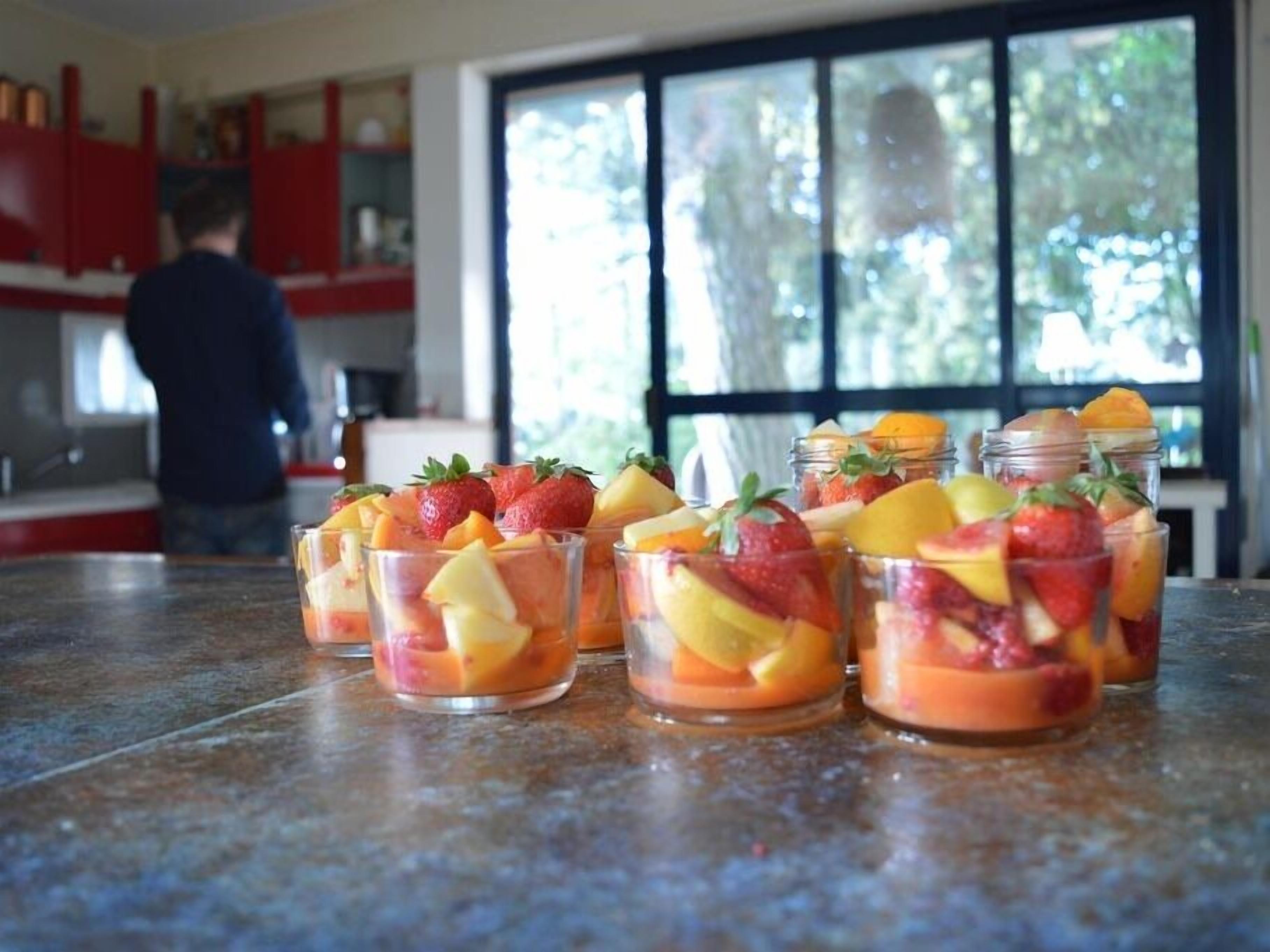 A kitchen counter with fruit parfaits and a person in the background.