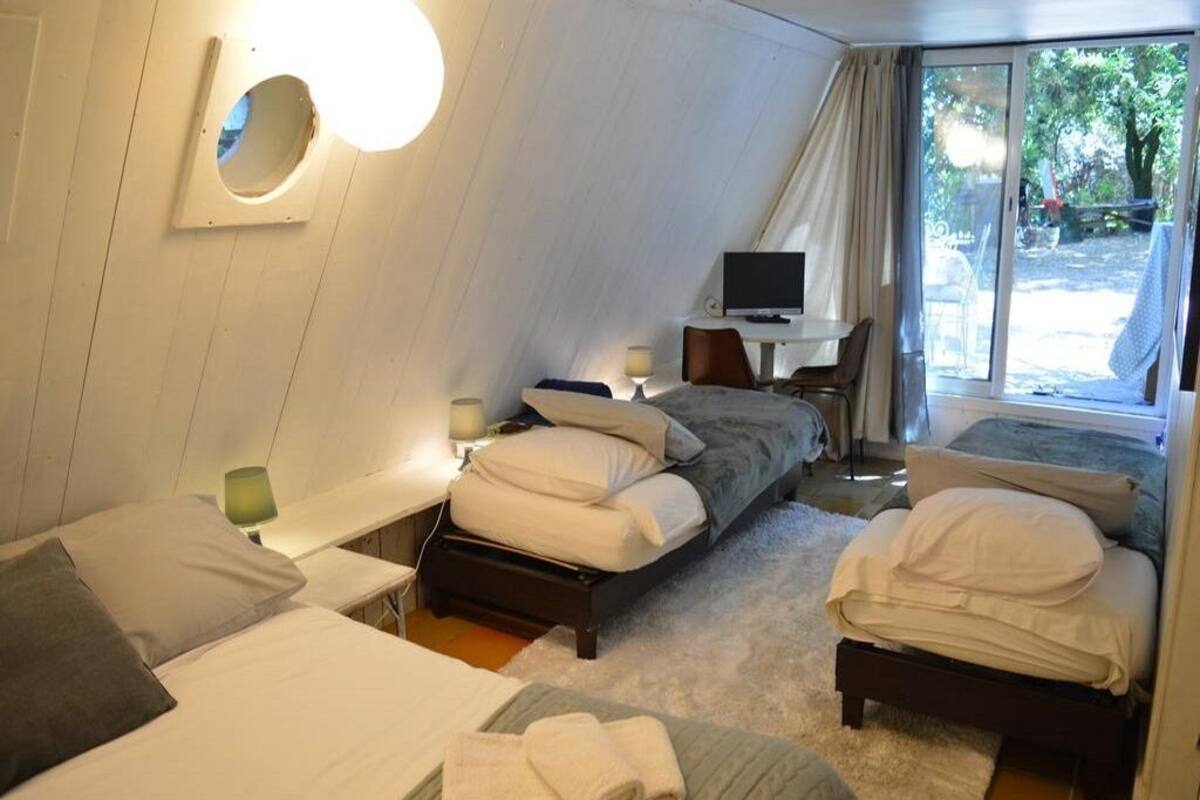 Une chambre avec deux lits, un bureau et une télévision.