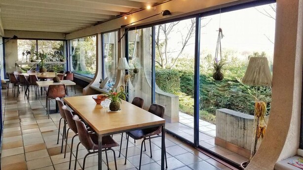 An indoor dining area with large windows, a tiled floor, and modern furniture. - Casa Marta : Suites - Terrasses et vue Panoramique (Tournon-sur-Rhone)