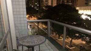 A balcony with a tiled floor, a round table with a patterned tablecloth, and a chair with a blue cushion. - Apart Quartier Latin Hotel (Vitoria)