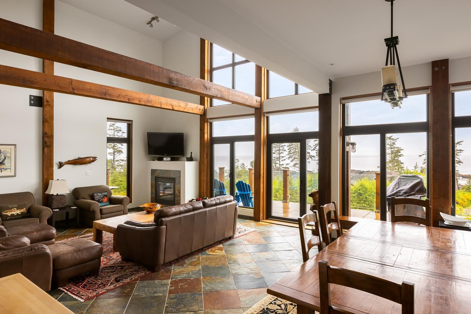 Un salón amplio con chimenea, ventanas grandes y vistas al exterior.