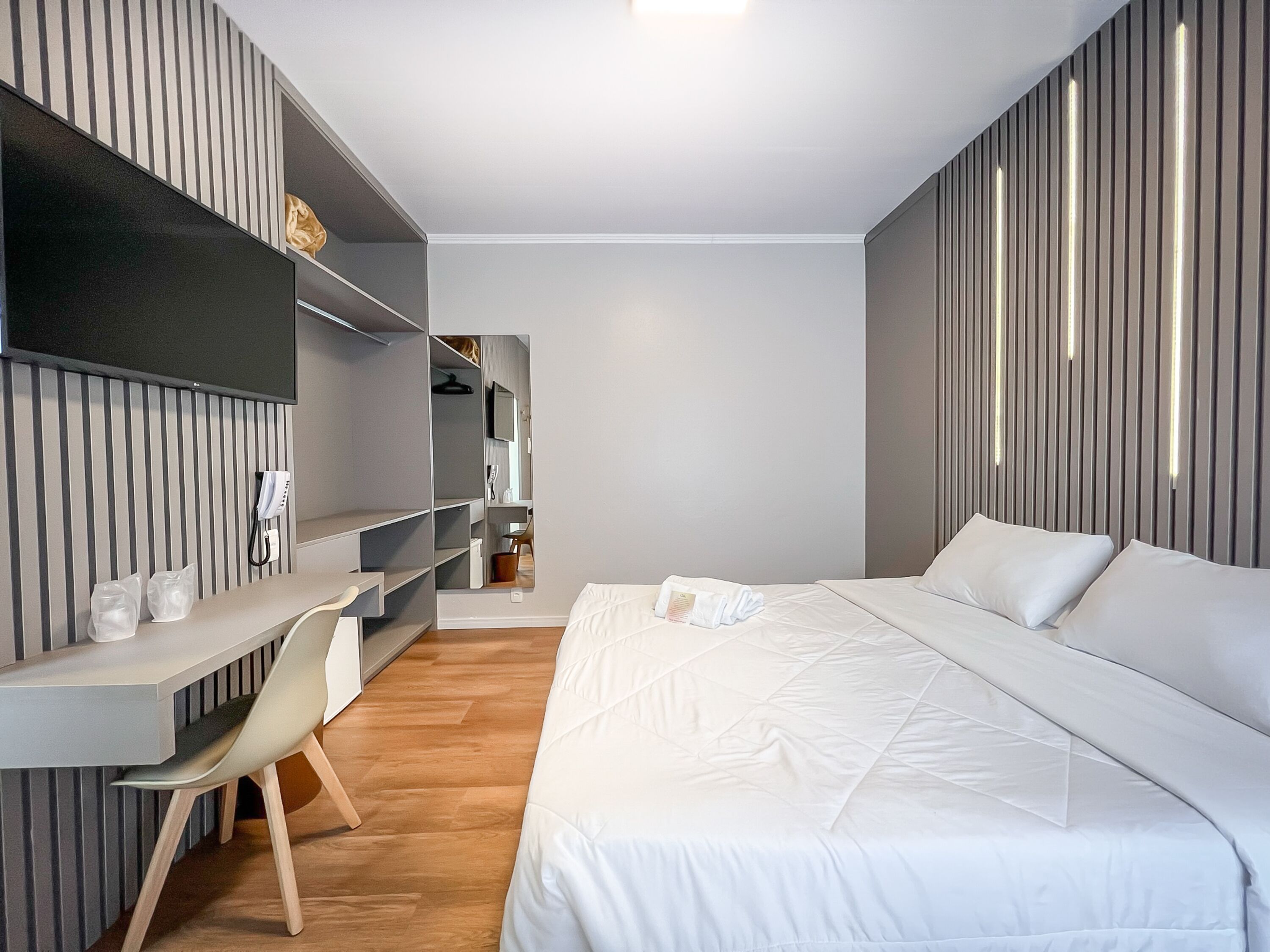Una camera d'albergo moderna con un letto, una scrivania e una sedia.