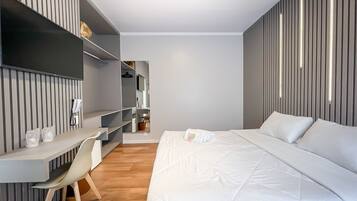 Una camera d'albergo moderna con un letto, una scrivania e una sedia.