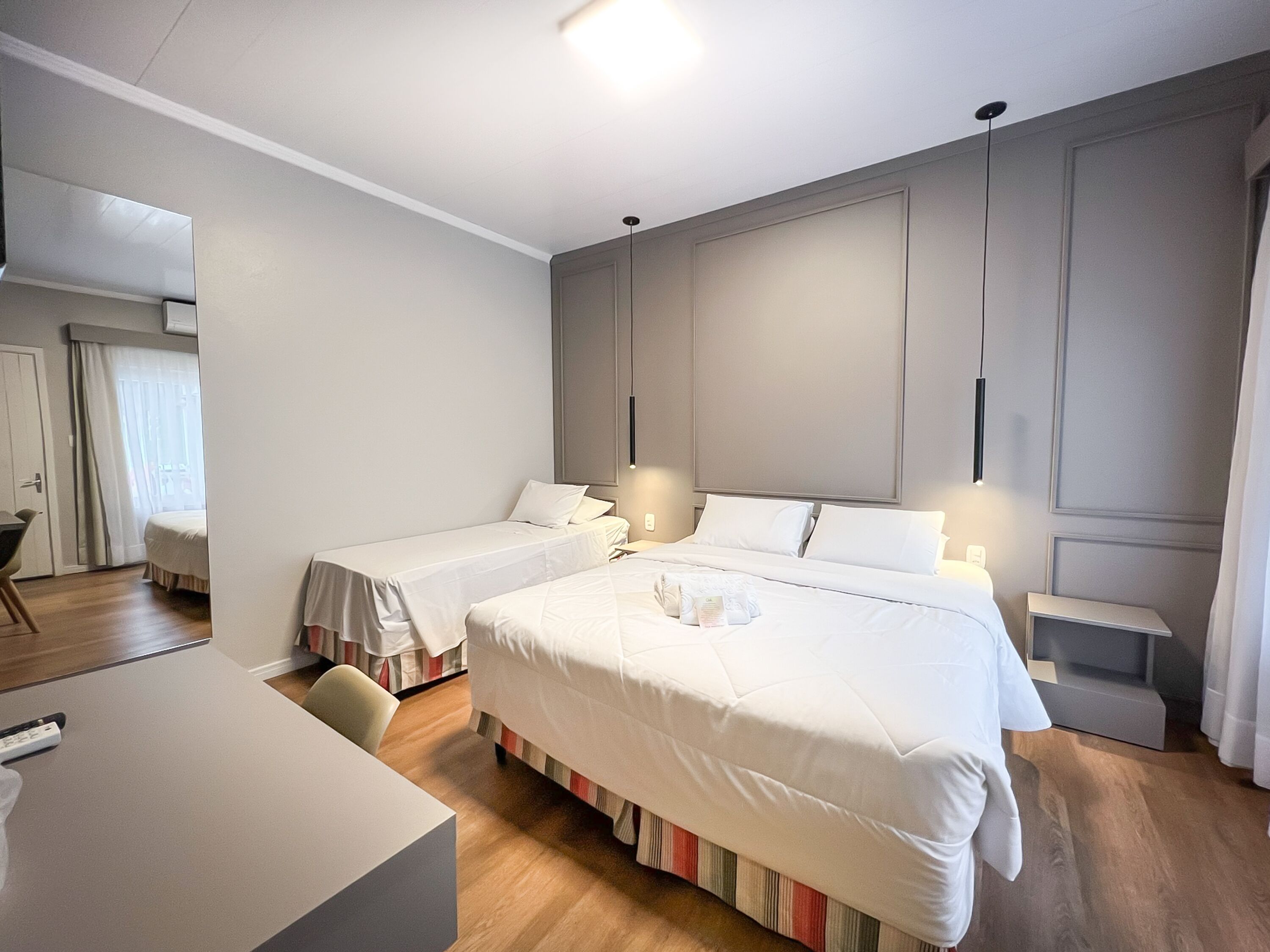 Ett hotellrum med två separata sängar, ett skrivbord och en stol.