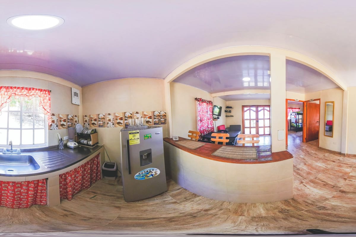 Una cocina con una isla central, un refrigerador y un lavamanos.