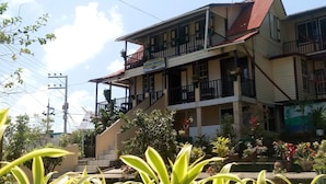 A multi-story building with balconies, a staircase, and potted plants.