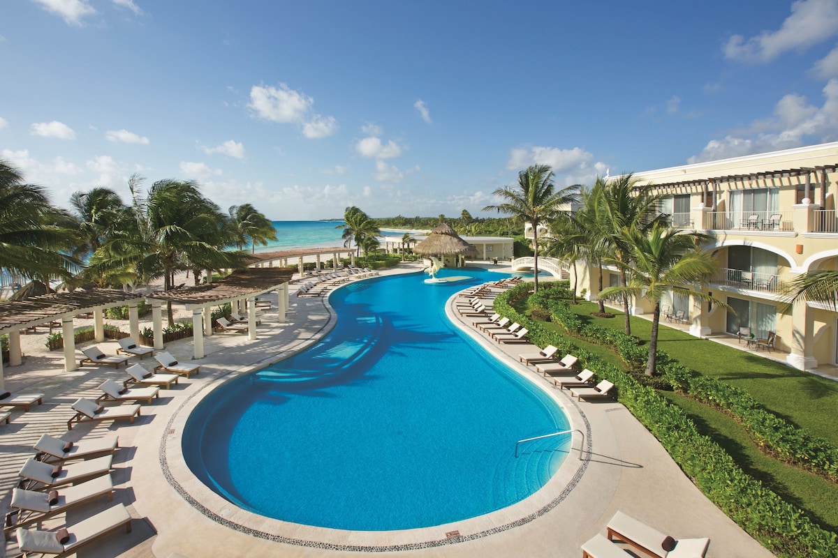 huge pool area of Dreams Tulum Resort & Spa with multiple sun loungers