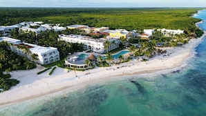 An aerial view of a resort with multiple buildings, a beach, and a pool area. - Dreams Tulum Resort & Spa - All Inclusive (Tulum)