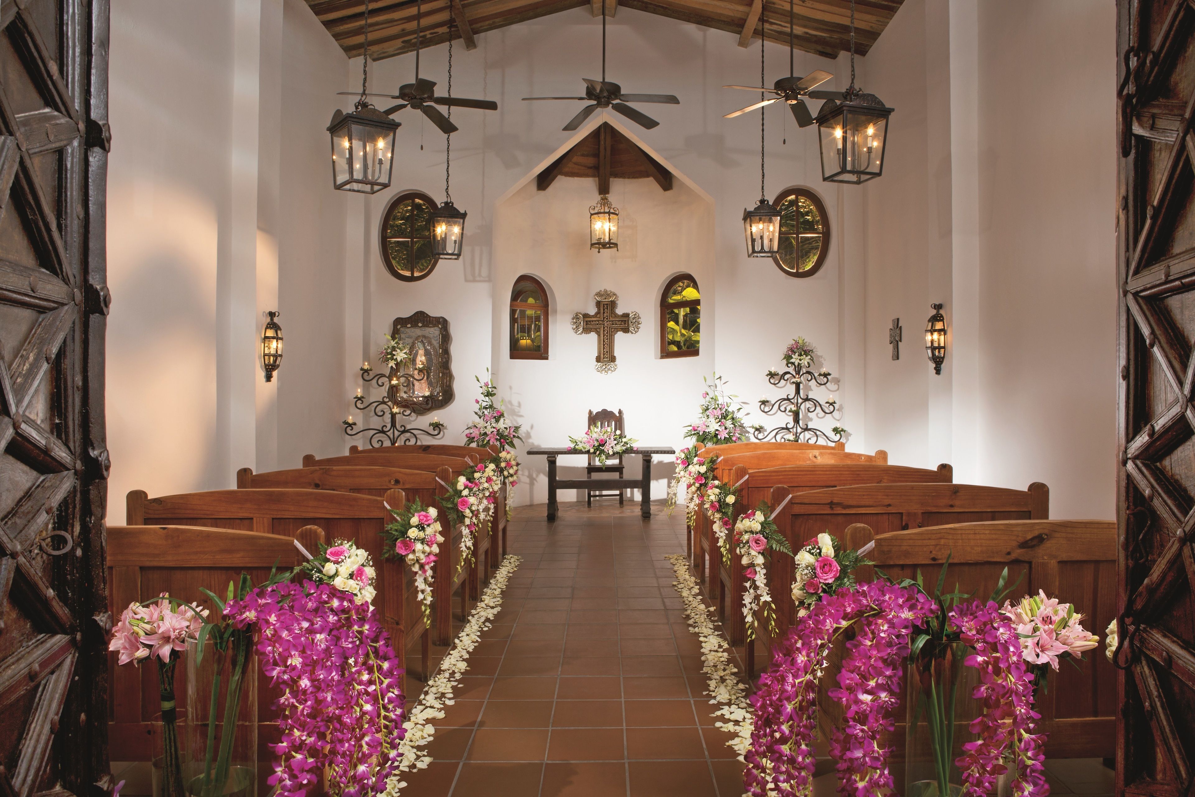 Interior d'una església amb pews de fusta, un passadís central i decoracions florals.