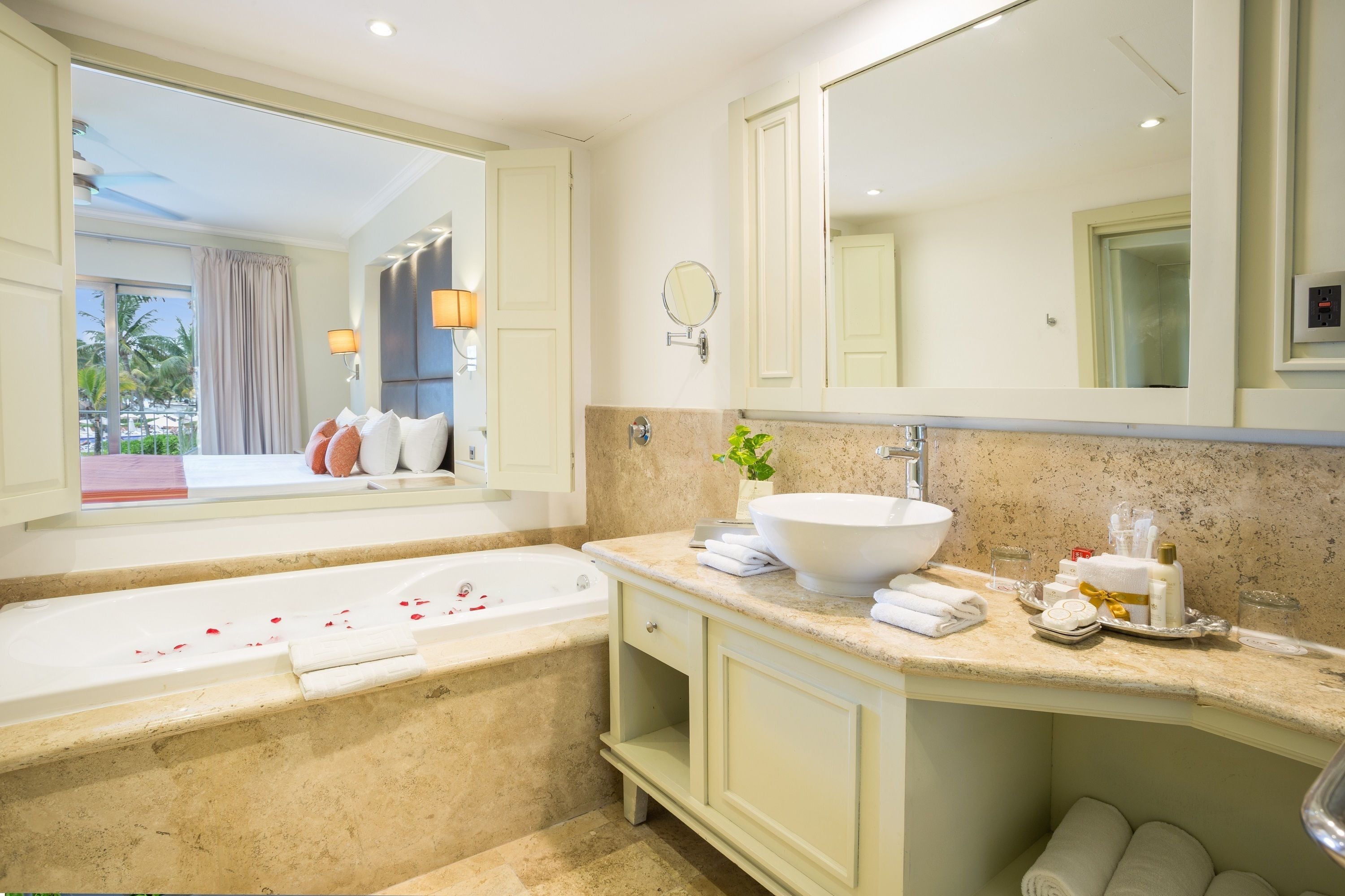 Un baño moderno con una bañera grande, un lavabo y un espejo sobre él.