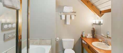 A bathroom with a bathtub, toilet, and sink.