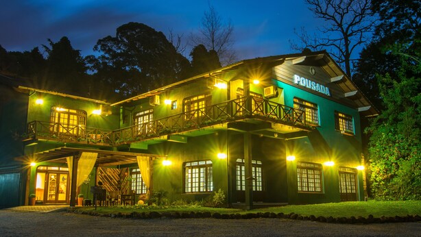 A two-story building with a balcony and a sign that reads "POUSADA". - Pousada Três Pinheiros (Gramado)