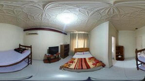 A room with two beds, a television, a wardrobe, and a ceiling with intricate patterns. - Pousada Parque Praia (Penha)